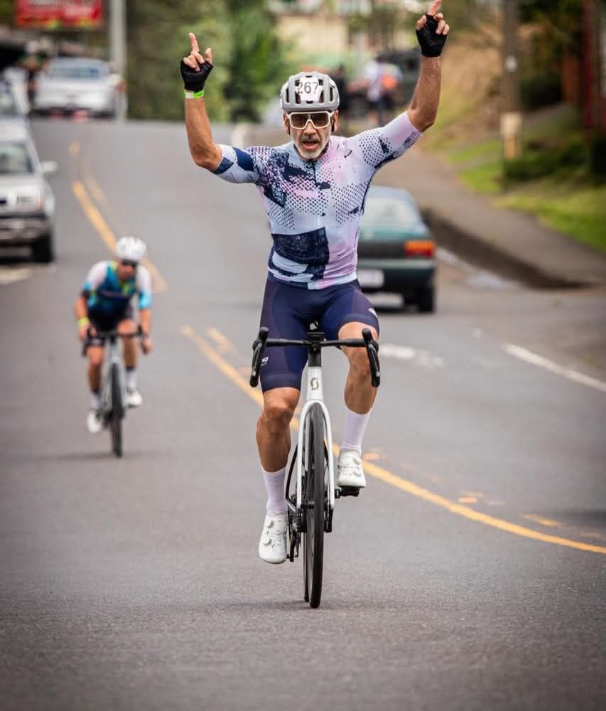 Ciclista celebra con los brazos arriba al cruzar la meta de la Copa ROES